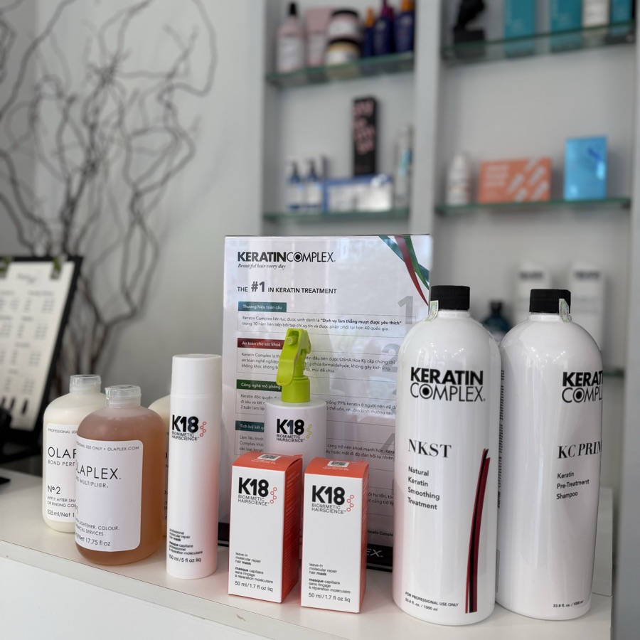 Kệ sản phẩm Olaplex, K18 và Keratin Complex đặt trên quầy
